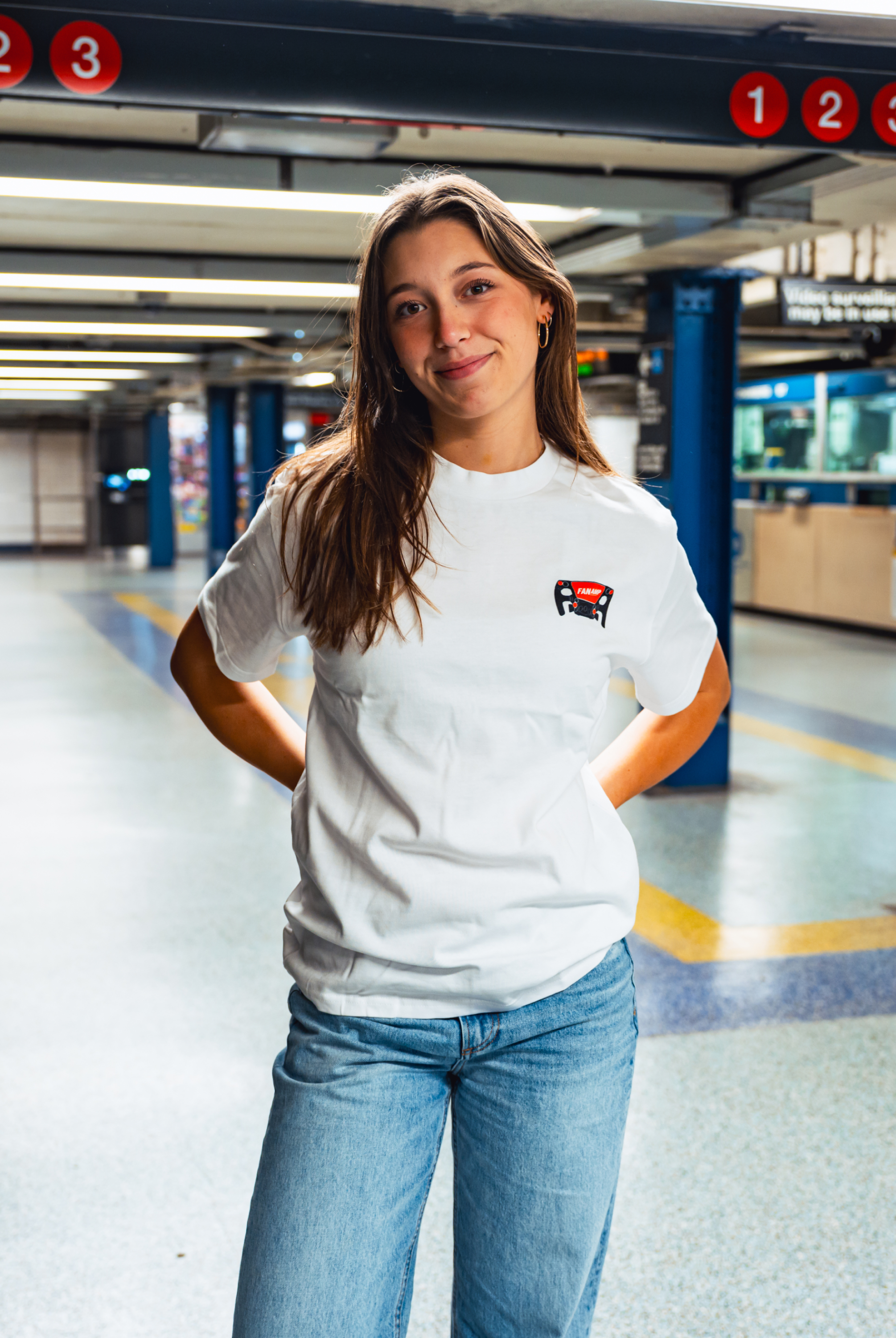 Model in NYC subway showing the front of the white Make The Pass t-shirt