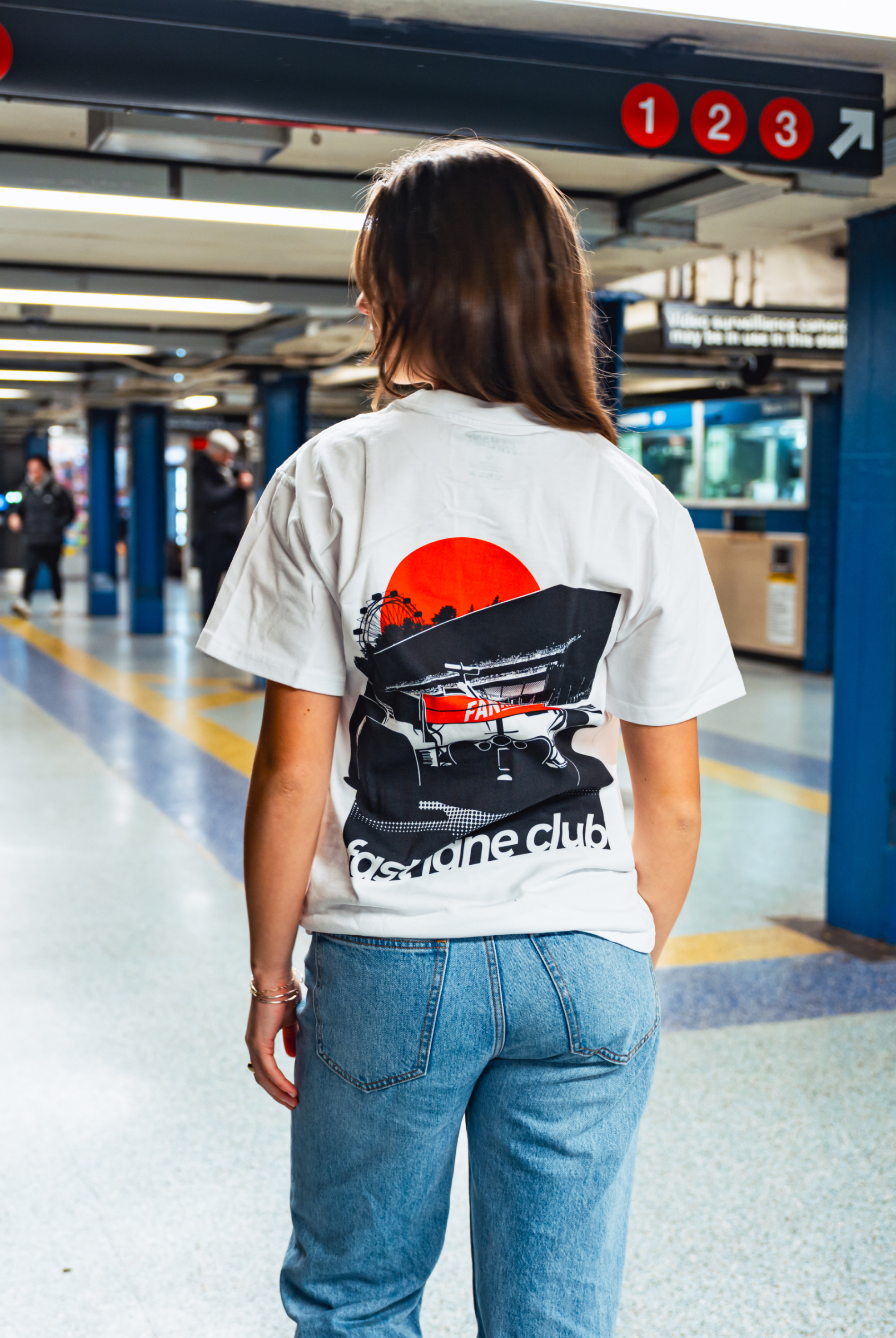 Model in NYC subway showing the back of the white Make The Pass t-shirt