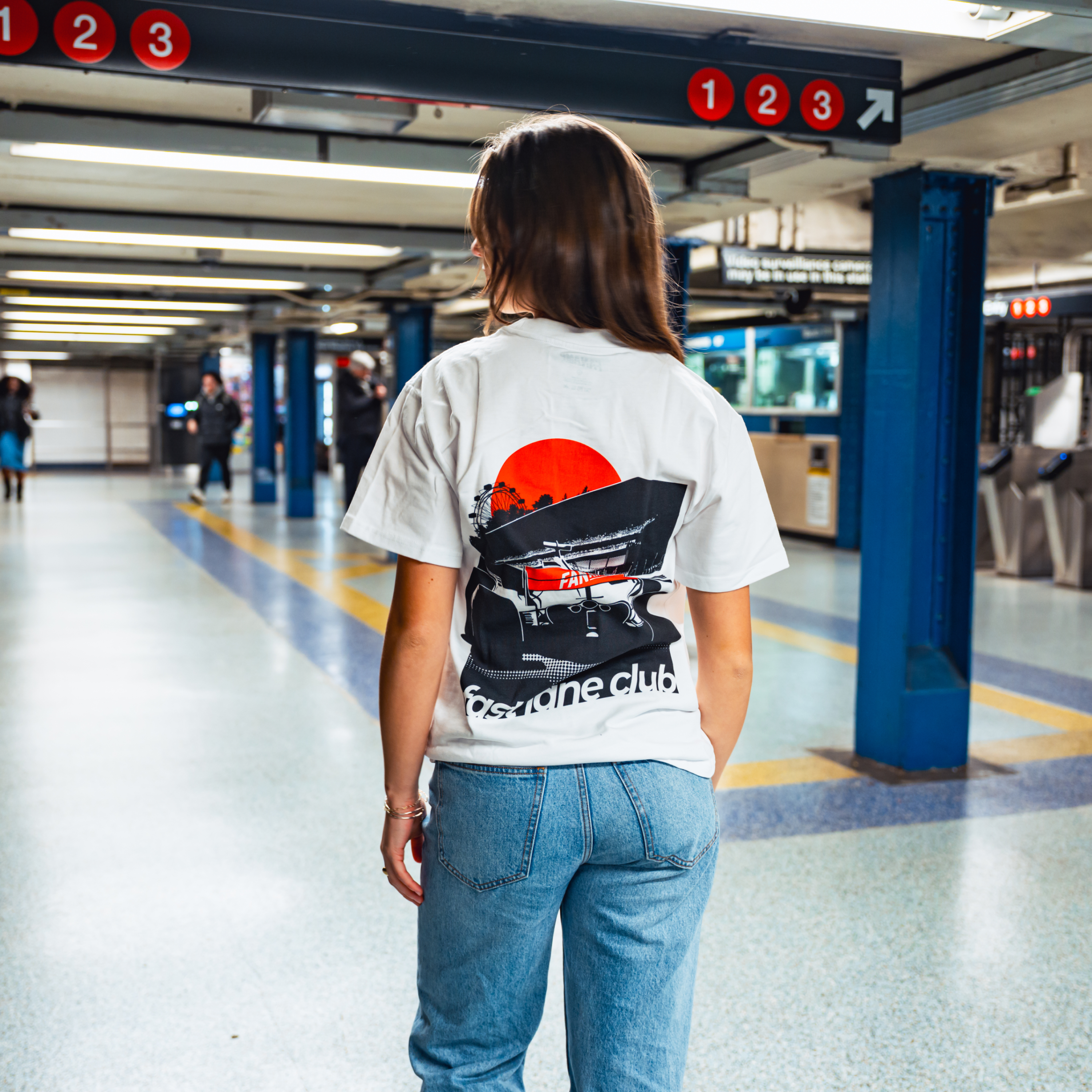 Model in NYC subway showing the back of the white Make The Pass t-shirt