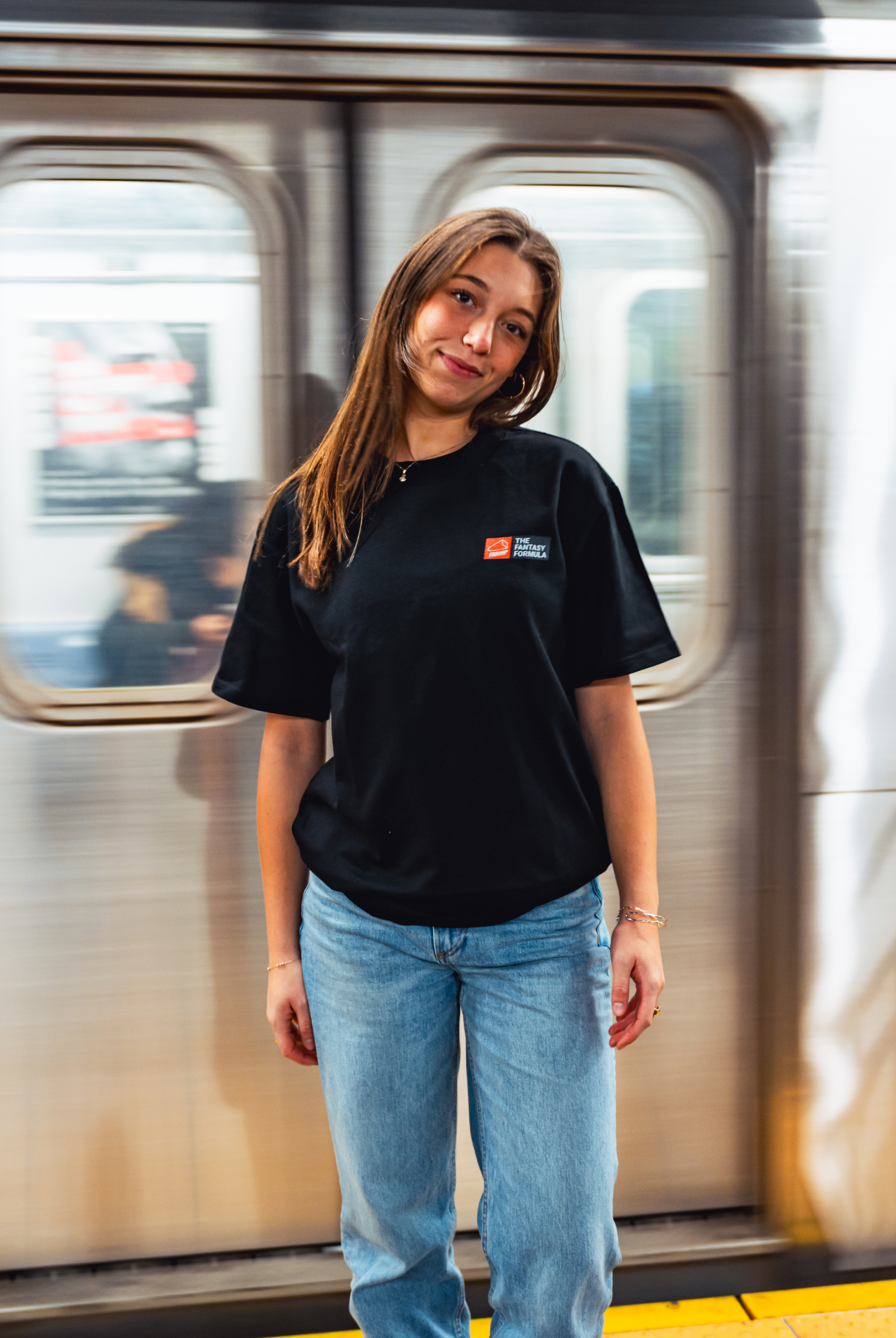 Model in NYC subway showing the front of the Black Fantasy Strategist t-shirt