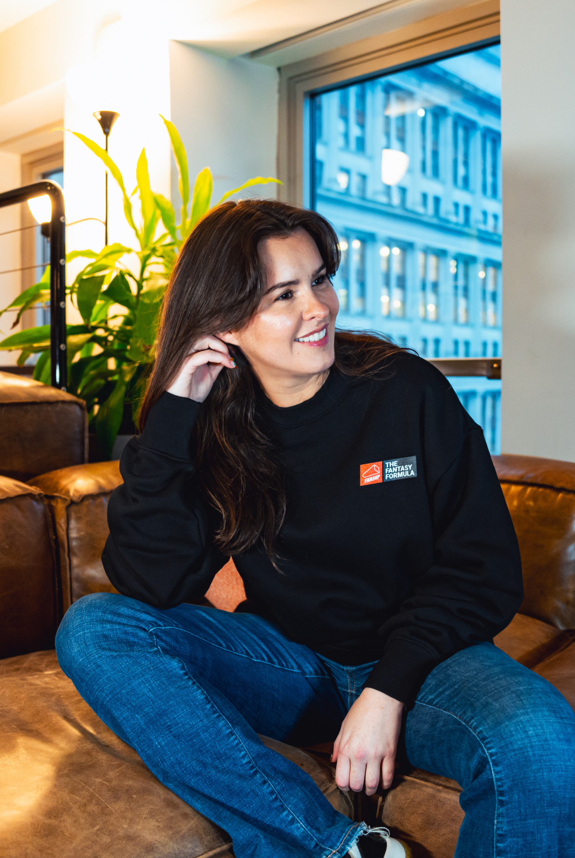 Model in NYC office showing the front of the black Fantasy Strategist crewneck