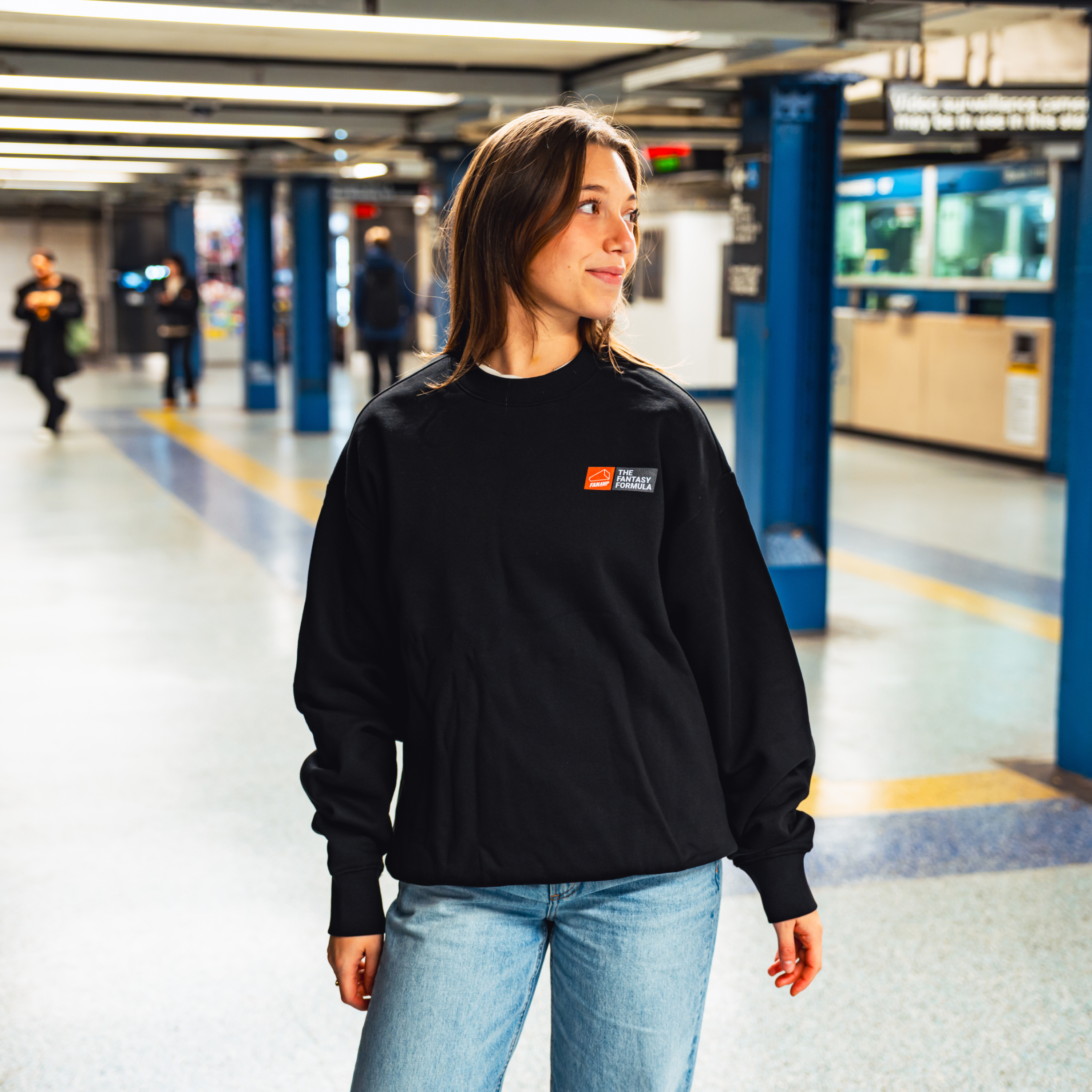 Model in NYC subway showing the front of the Black Fantasy Strategist crewneck