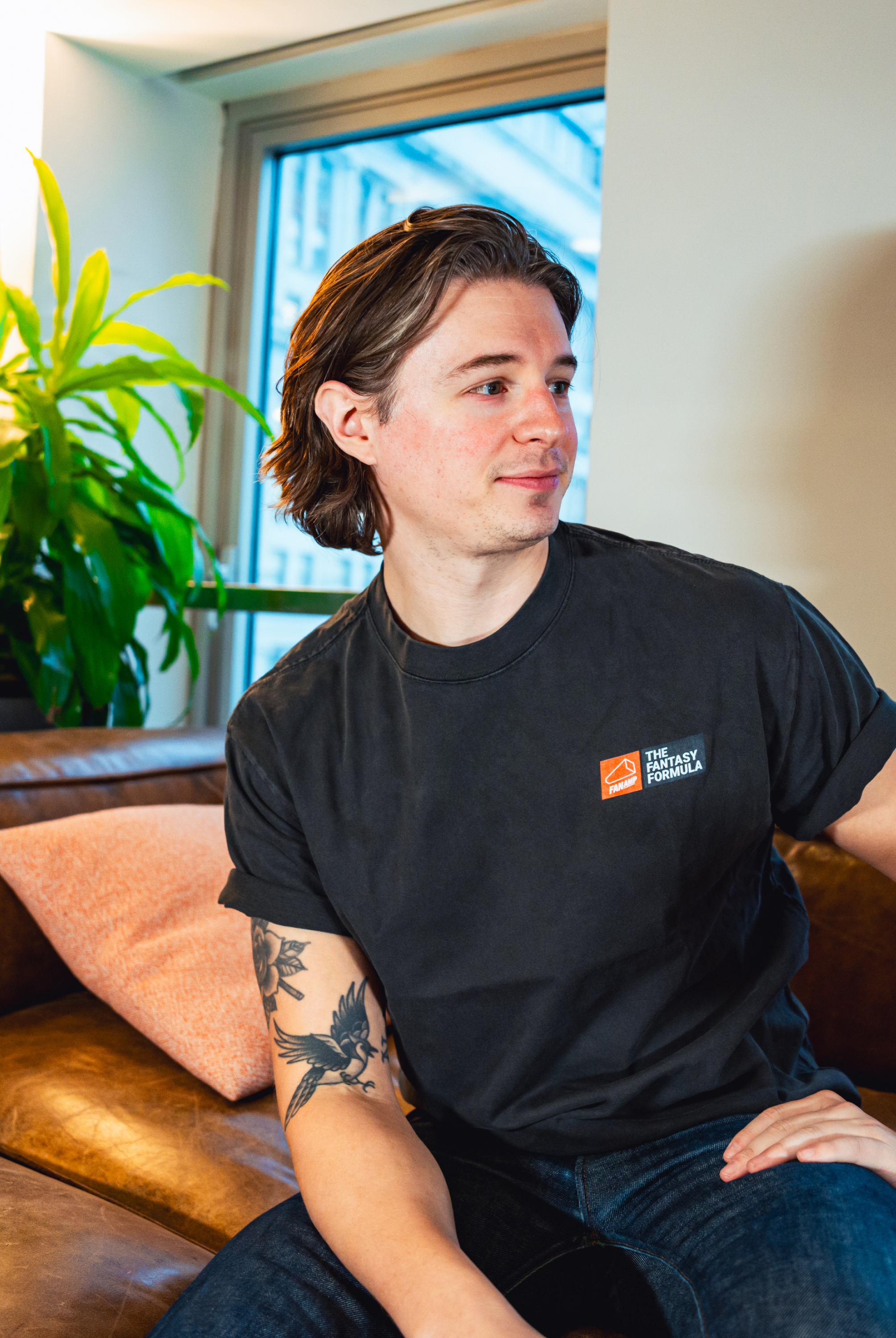 Model in NYC office showing the front of the Faded Coal Fantasy Strategist t-shirt
