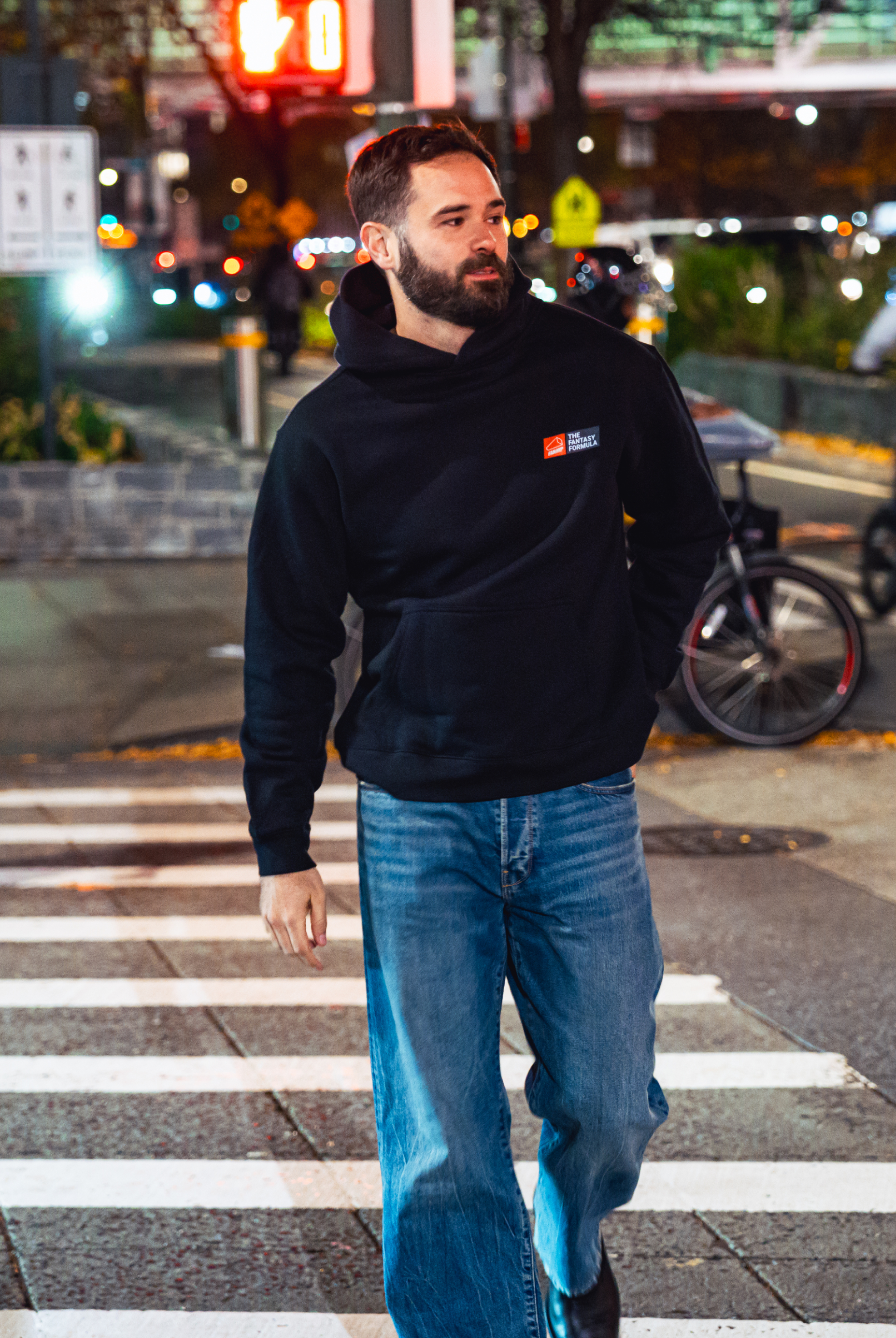 Model in NYC showing the front of the black Fantasy Strategist hoodie