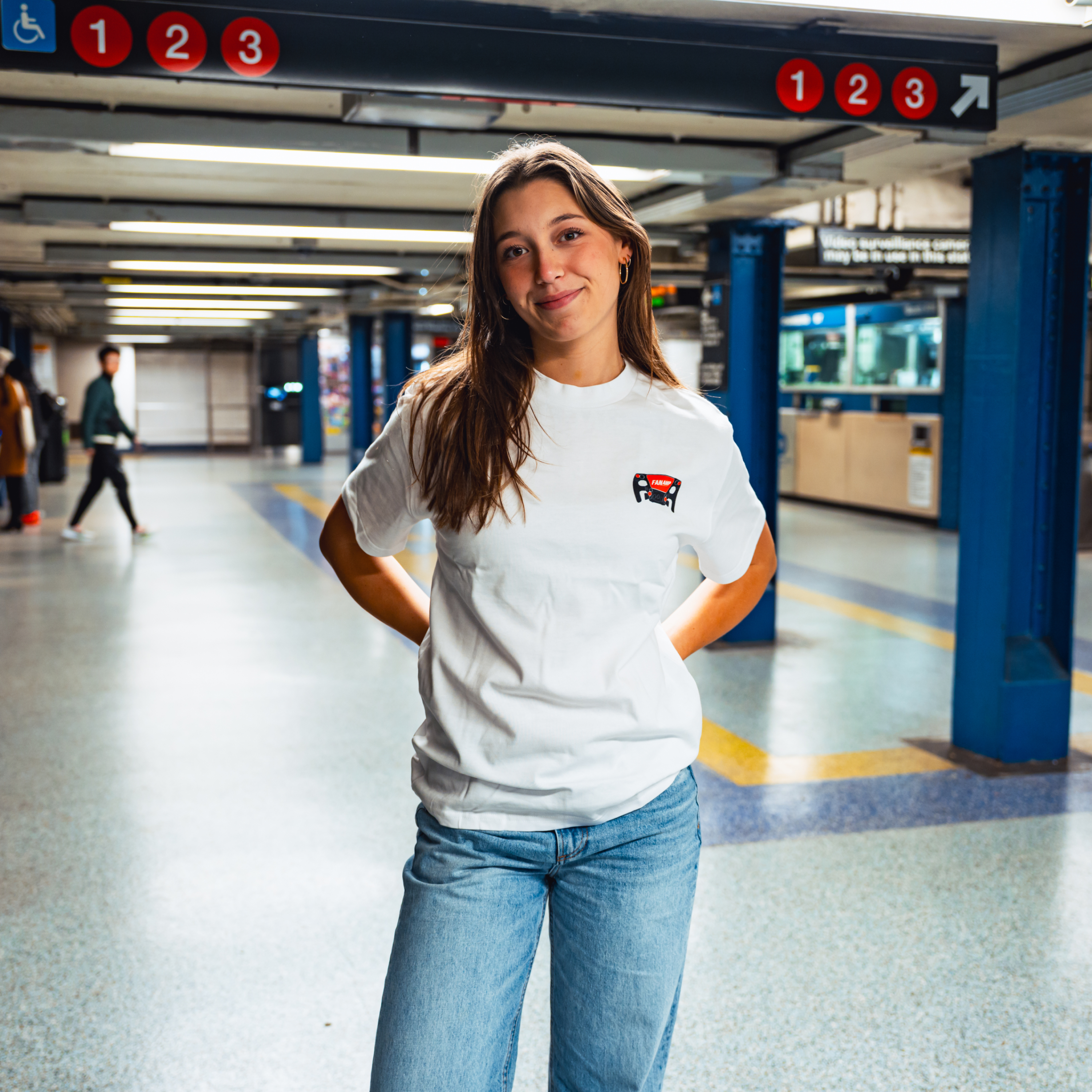 Model in NYC subway showing the front of the white Make The Pass t-shirt
