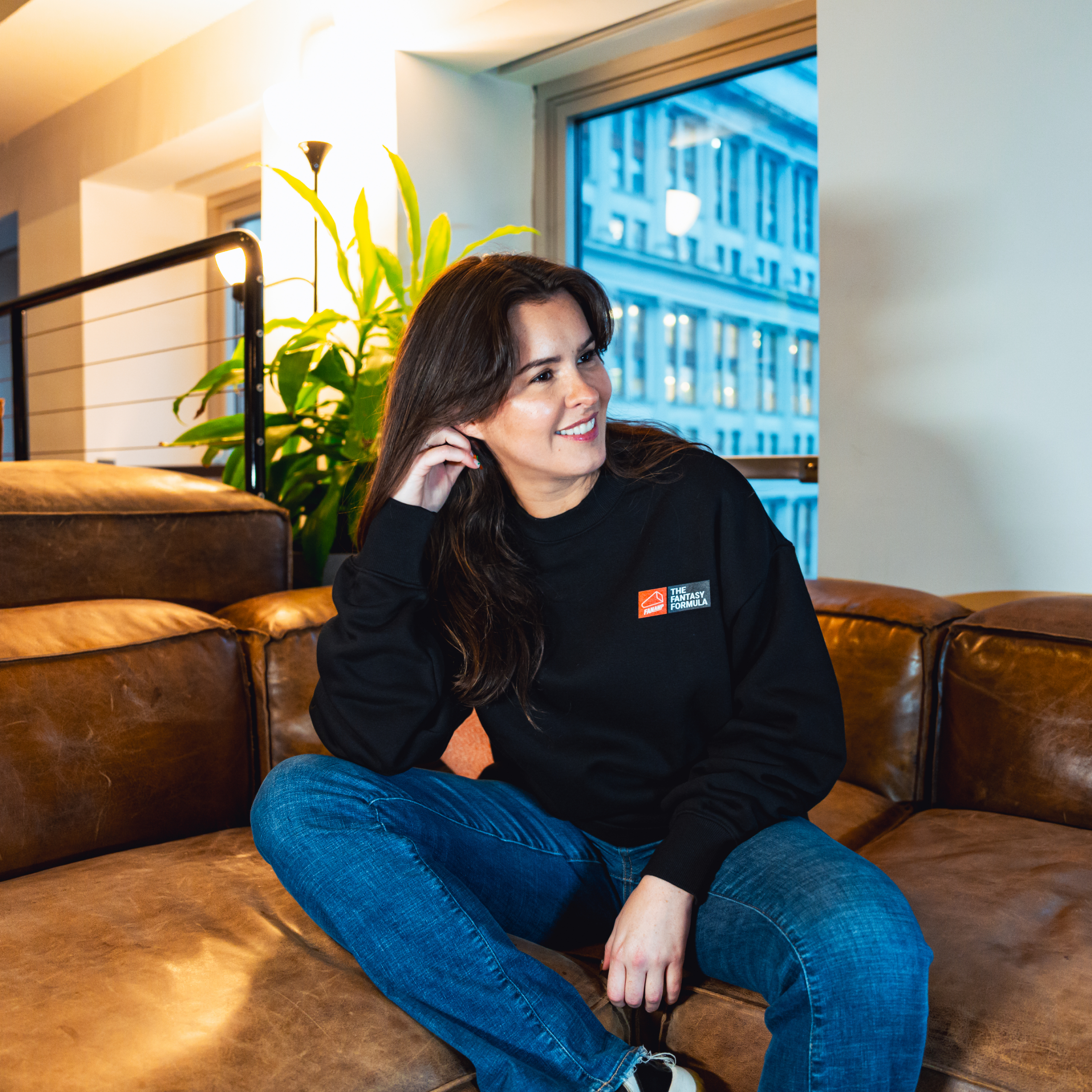 Model in NYC office showing the front of the black Fantasy Strategist crewneck