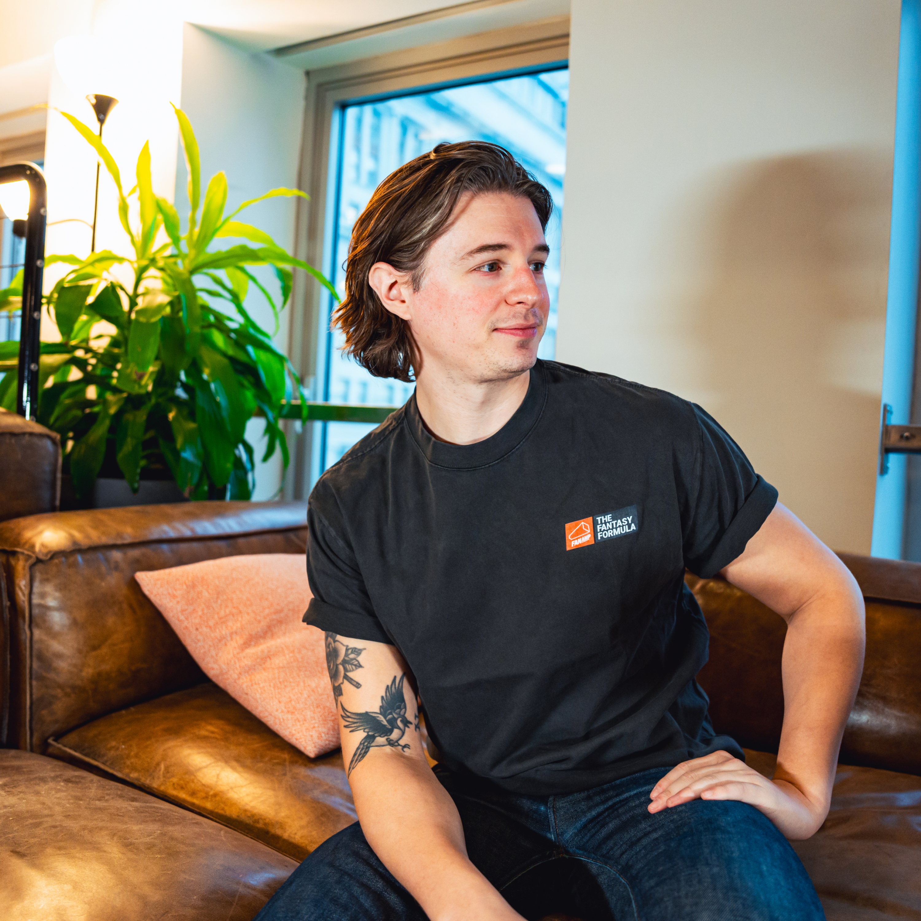 Model in NYC office showing the front of the Faded Coal Fantasy Strategist t-shirt